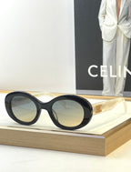 Black sunglasses with gold temple accents and light-tinted lenses
