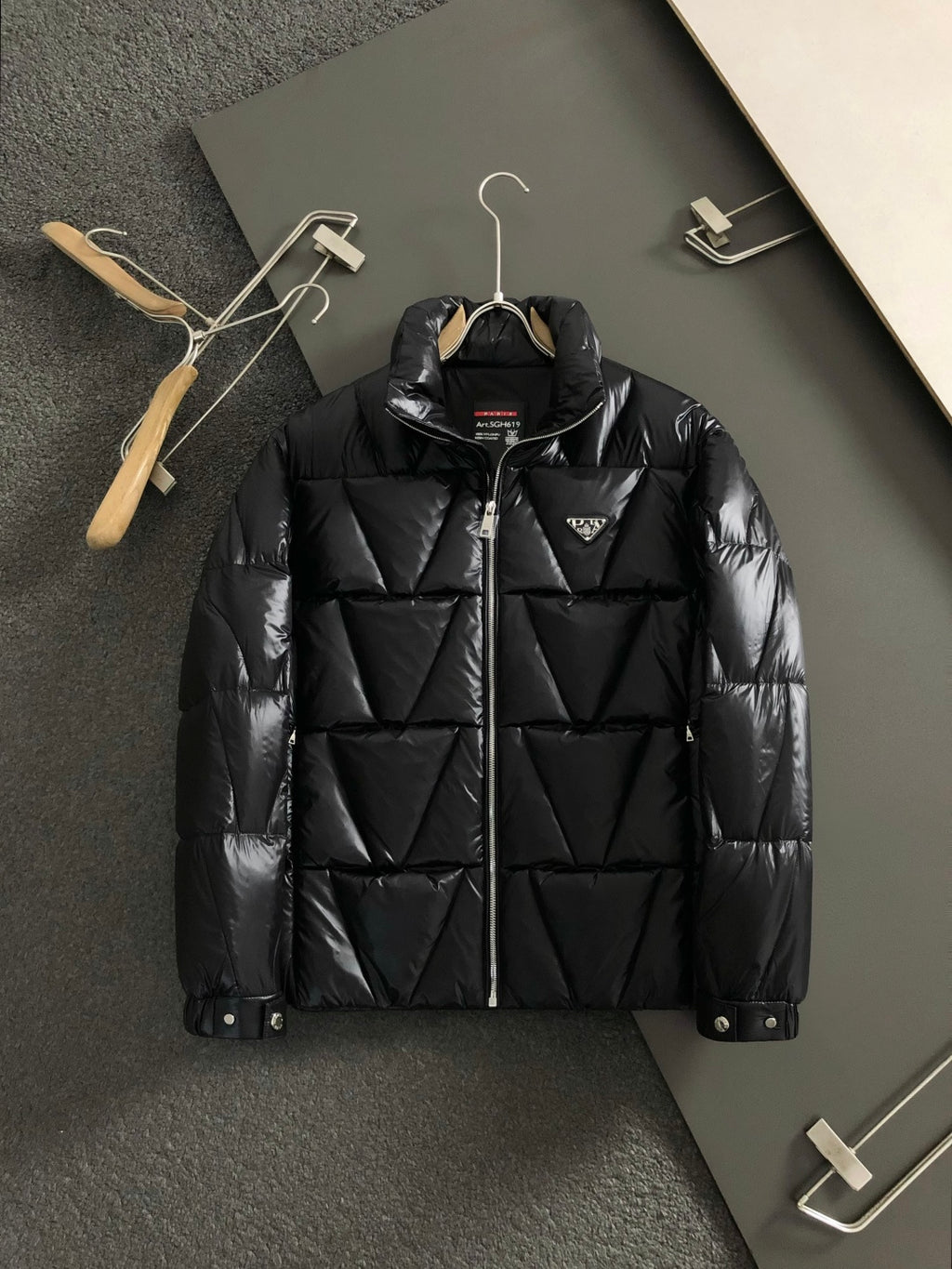 Black zip-front puffer jacket with stand collar and Prada patch logo