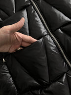 Black puffer jacket interior close-up with metal zipper and lining