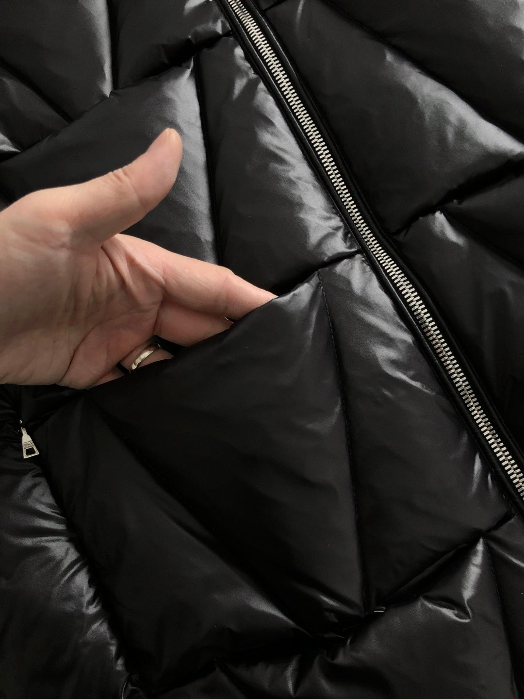 Black puffer jacket interior close-up with metal zipper and lining
