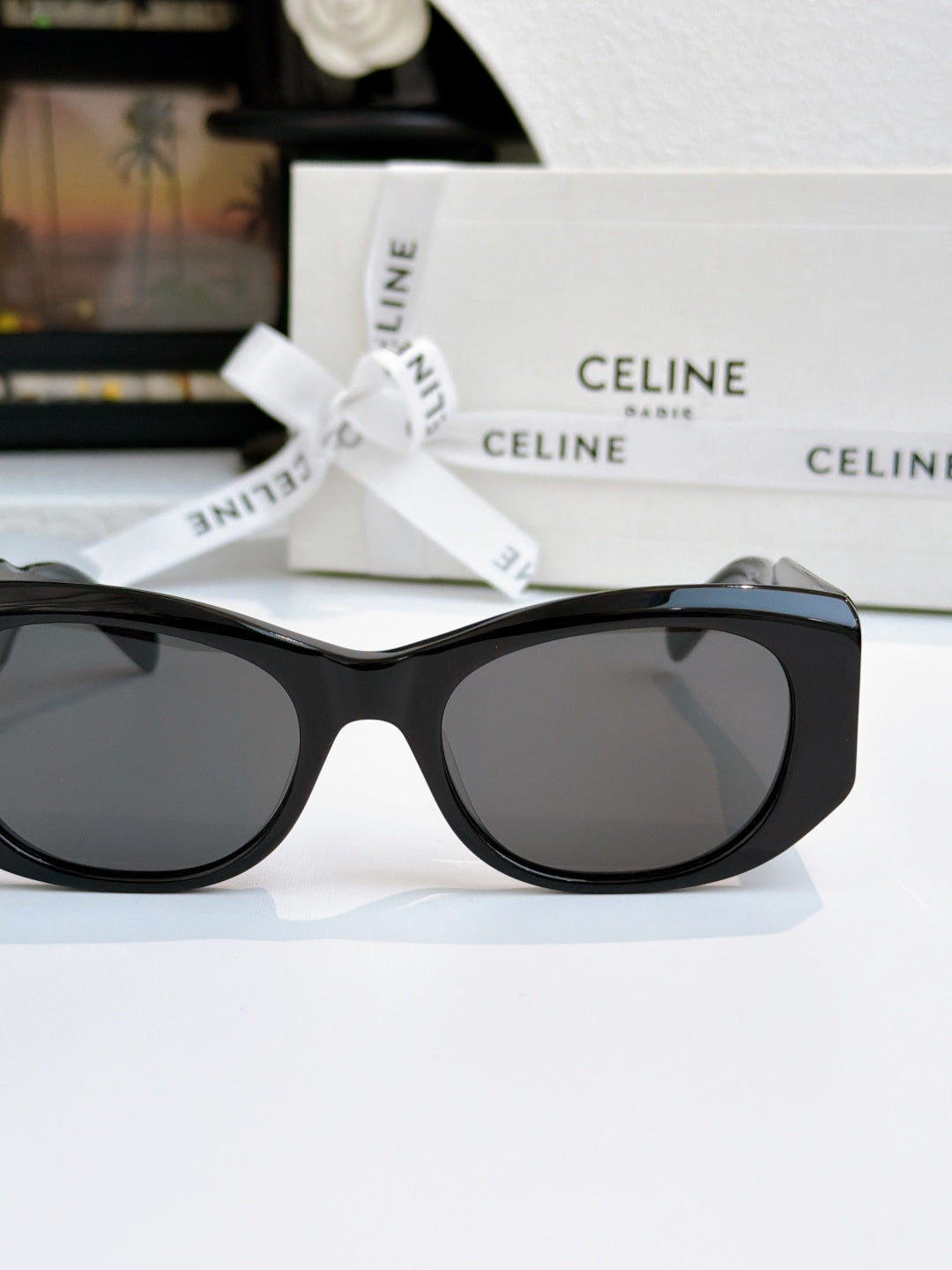 Cat-eye sunglasses with black frames and dark lenses, front view.
