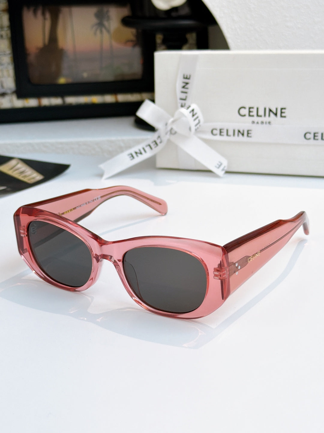 Cat-eye sunglasses with pink frames and dark gray lenses.