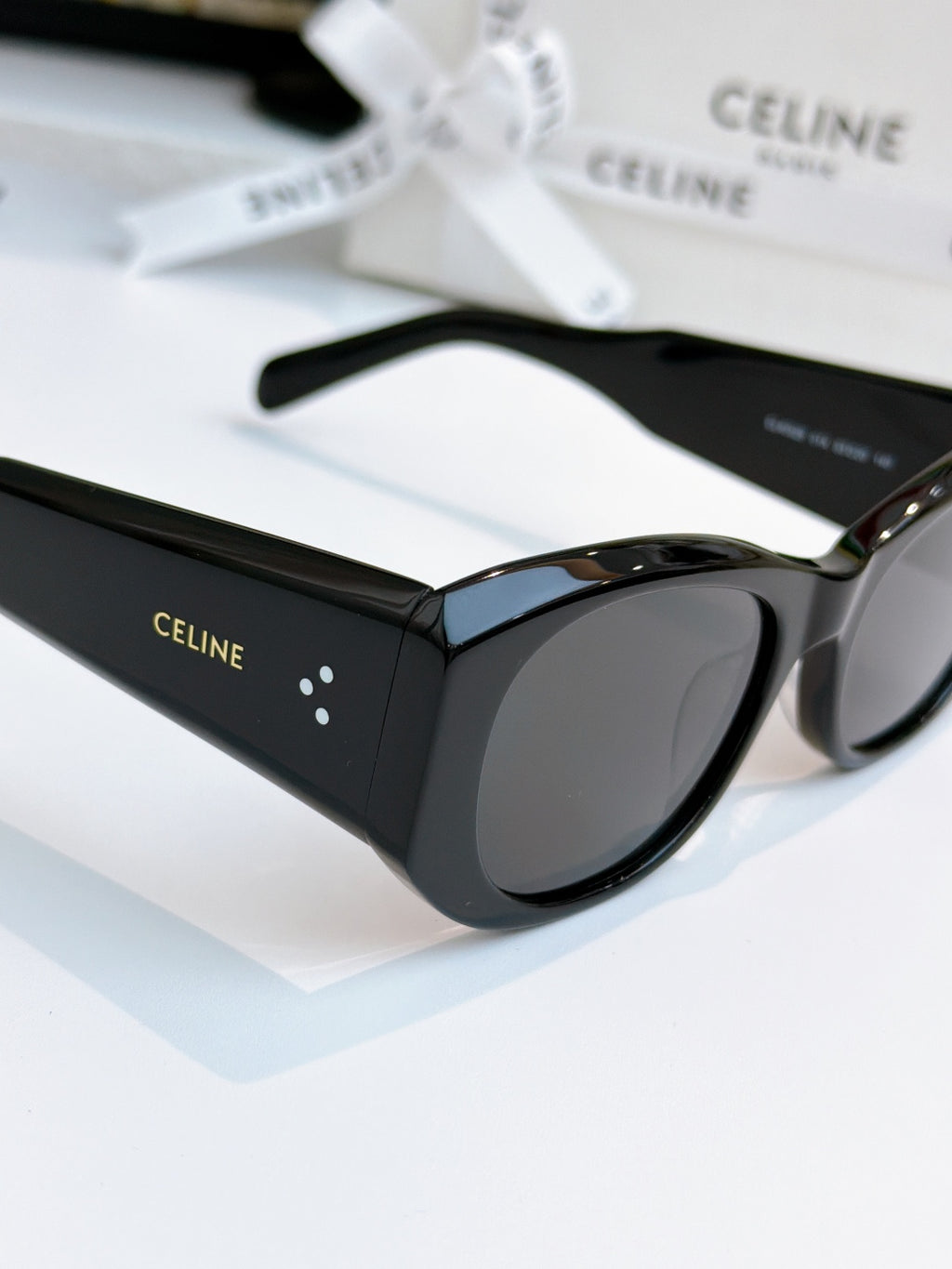 Cat-eye sunglasses with black frames and dark lenses, side view.