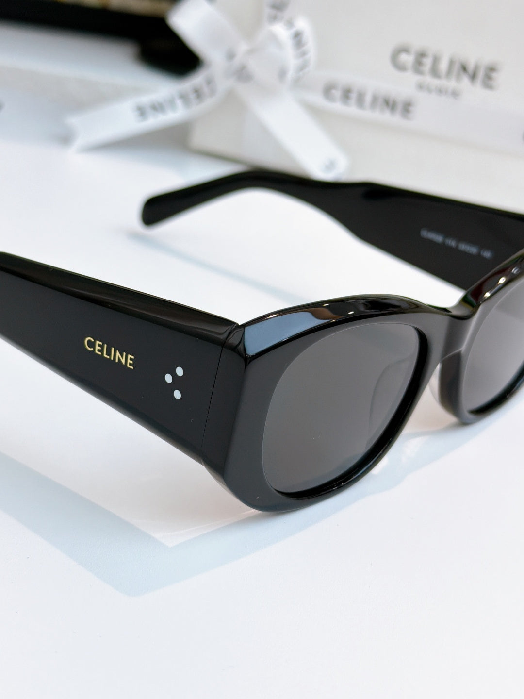 Cat-eye sunglasses with black frames and dark lenses, side view.