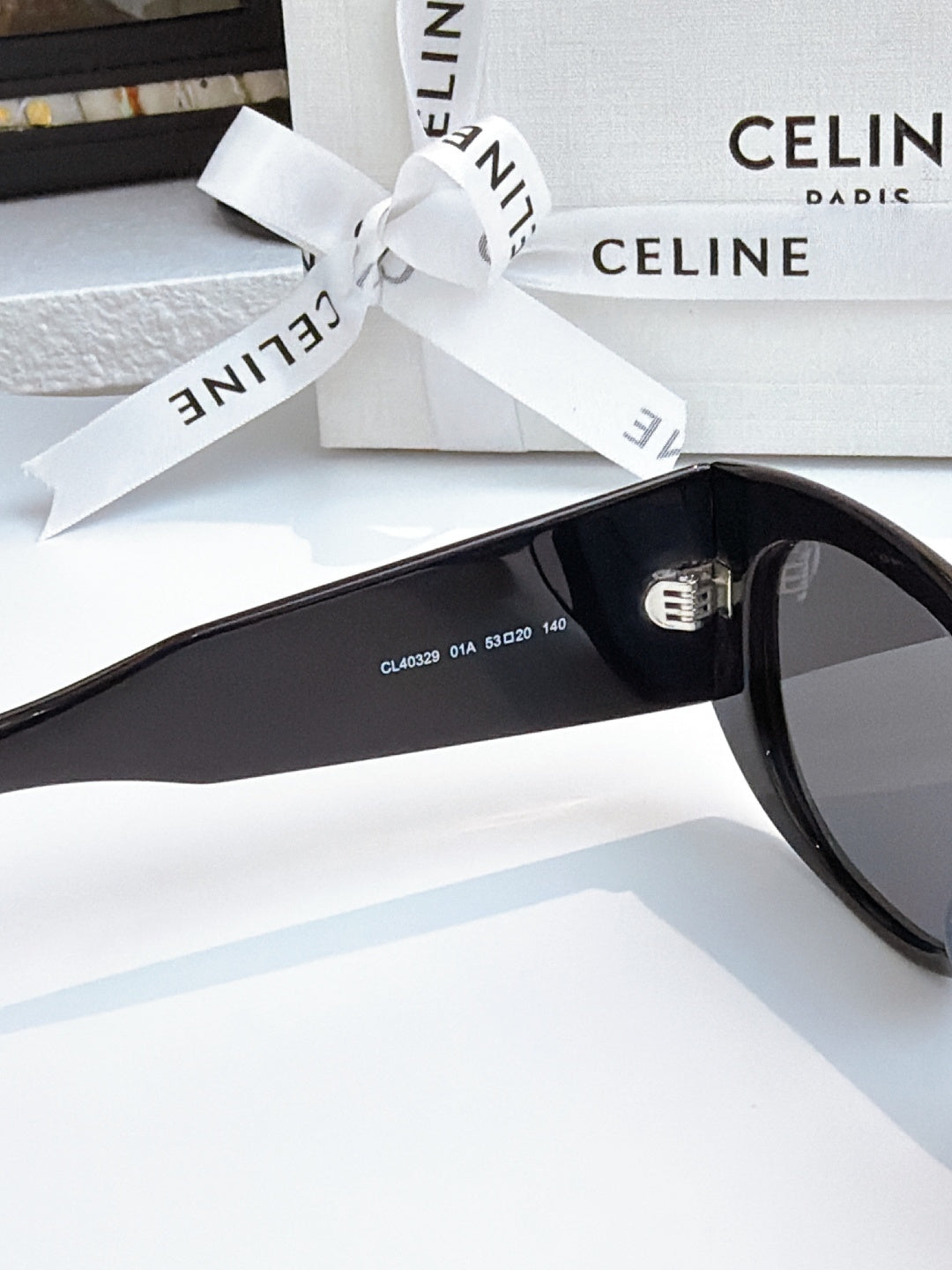 Cat-eye sunglasses with black frames and dark lenses, temple text visible.