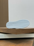 Outsole of black high-top sneakers with white zigzag tread