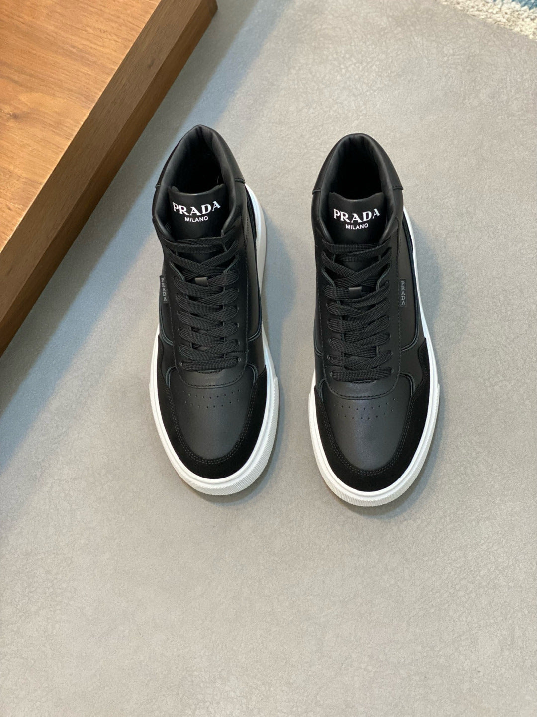 Prada black leather high-top sneakers with lace-up front and white rubber sole