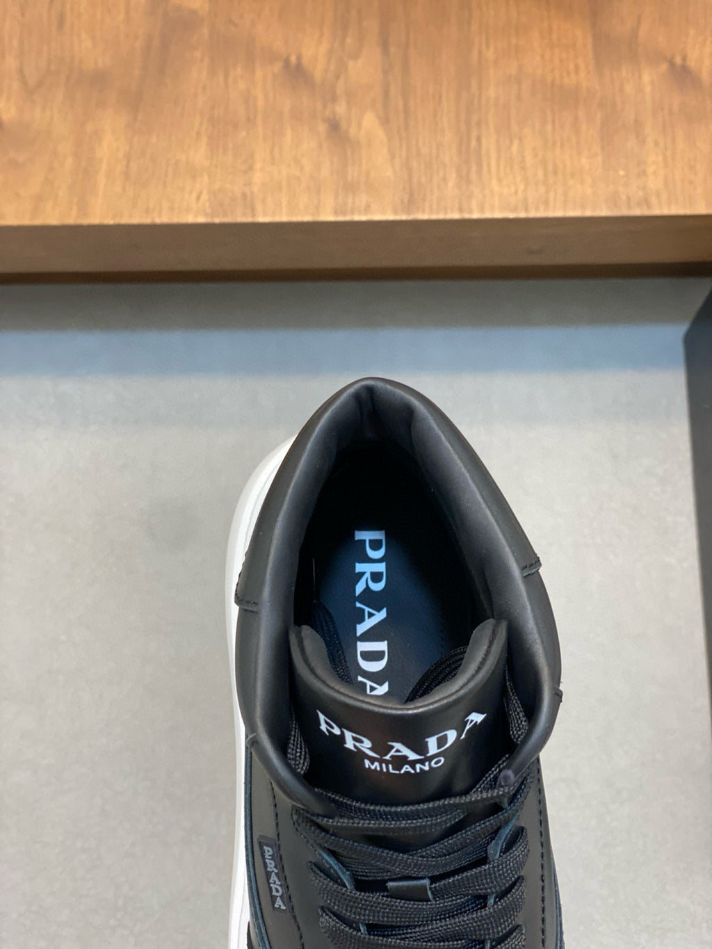 Black sneaker with Prada Milano logo on tongue and padded collar