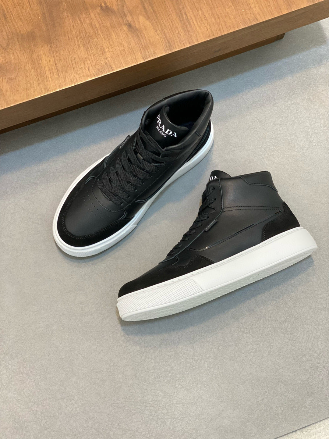 Pair of black lace-up high-top sneakers with white rubber sole