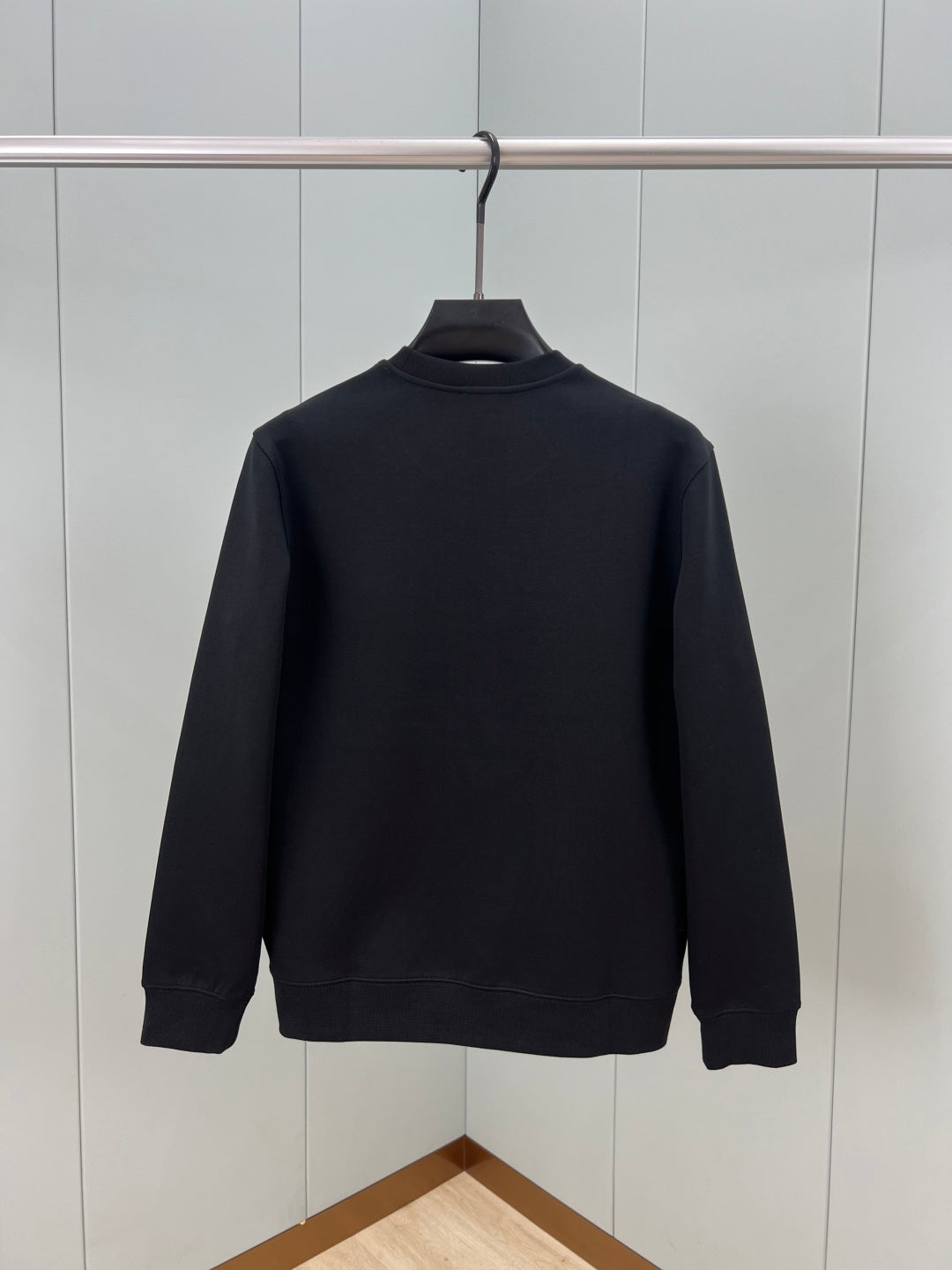 Black crewneck sweatshirt back view, solid knit with ribbed cuffs