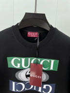 Black crewneck sweatshirt close-up with Gucci logo graphic and red tag