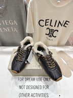 Golden Goose black sneaker pair with fuzzy white collar lining, gold lace-up, gum soles