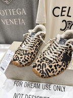Pair of leopard-print sneakers with sherpa trim, white laces, and gum soles