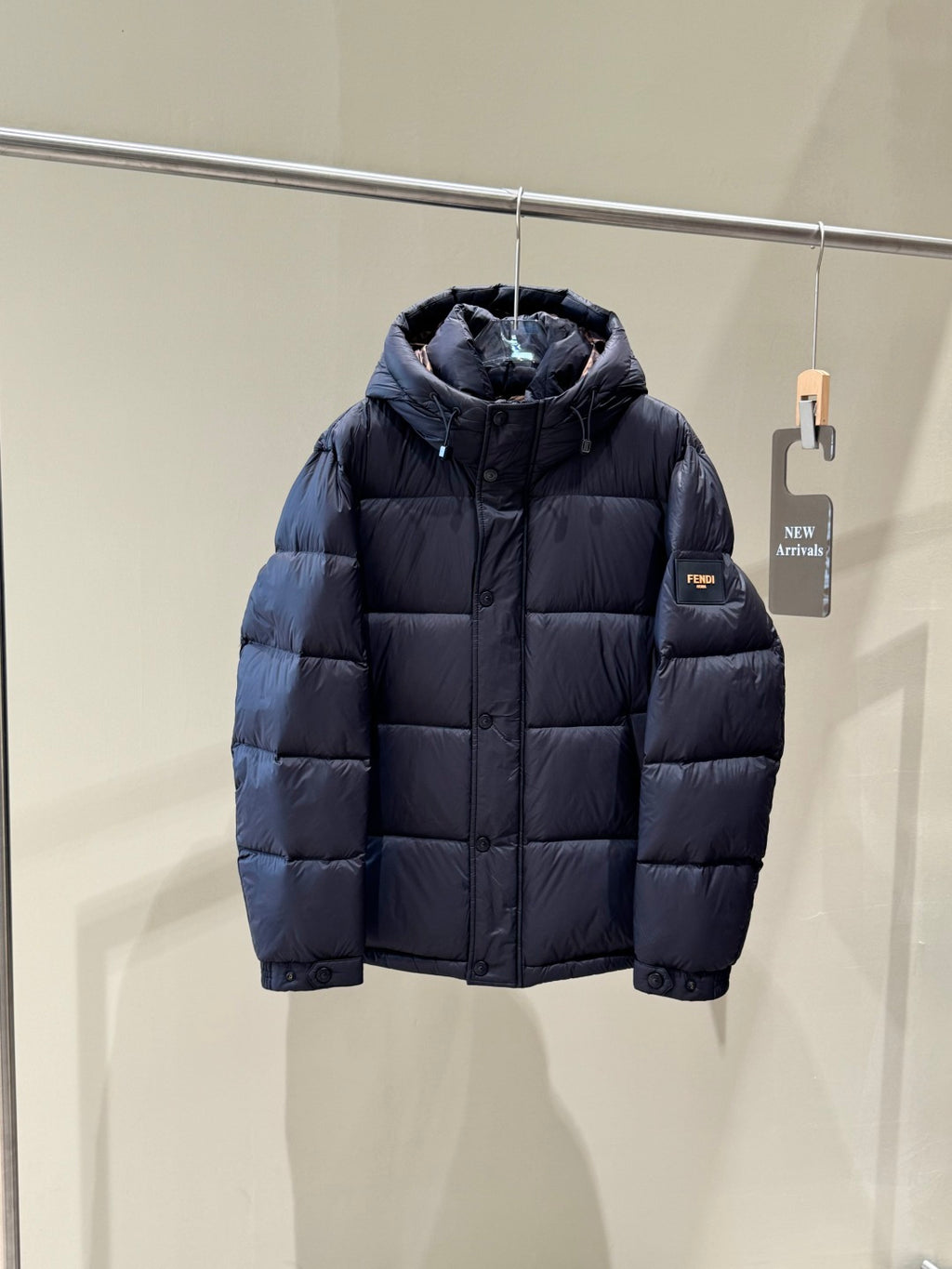 Dark hooded puffer jacket with zipper front and quilted padded panels.