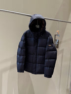 Dark hooded puffer jacket, back view with quilted panels and small logo patch.