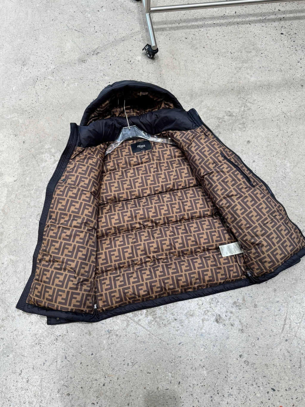 Dark puffer jacket with exposed patterned lining and hood interior detail.