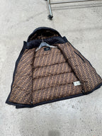 Dark puffer jacket with exposed patterned lining and hood interior detail.