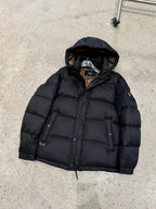 Dark hooded puffer jacket with zipper front and quilted insulation, laid flat.