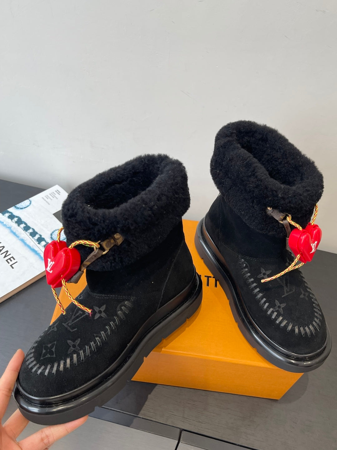 Pair of black monogram ankle boots with plush lining and red heart charm details