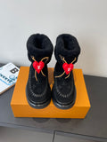 Black monogram ankle boots with plush lining, gold trim, and red heart charms