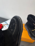 Side view of black monogram ankle boot with red heart charm and chunky sole