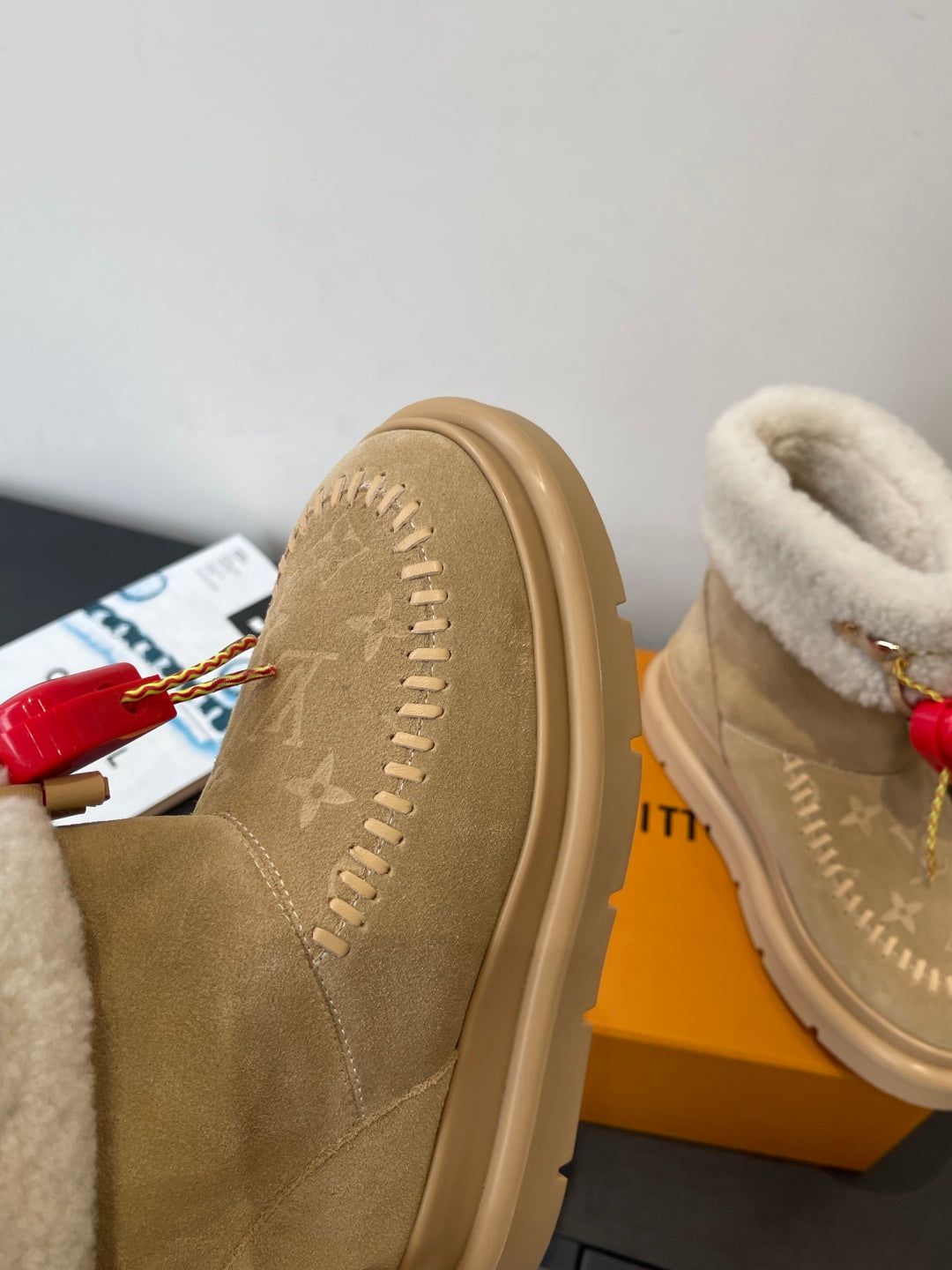 Louis Vuitton unisex tan suede shearling boots, side view with red heart charm