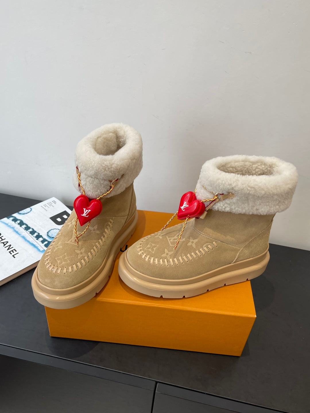 Louis Vuitton unisex tan suede shearling boots, angled view with red heart charm