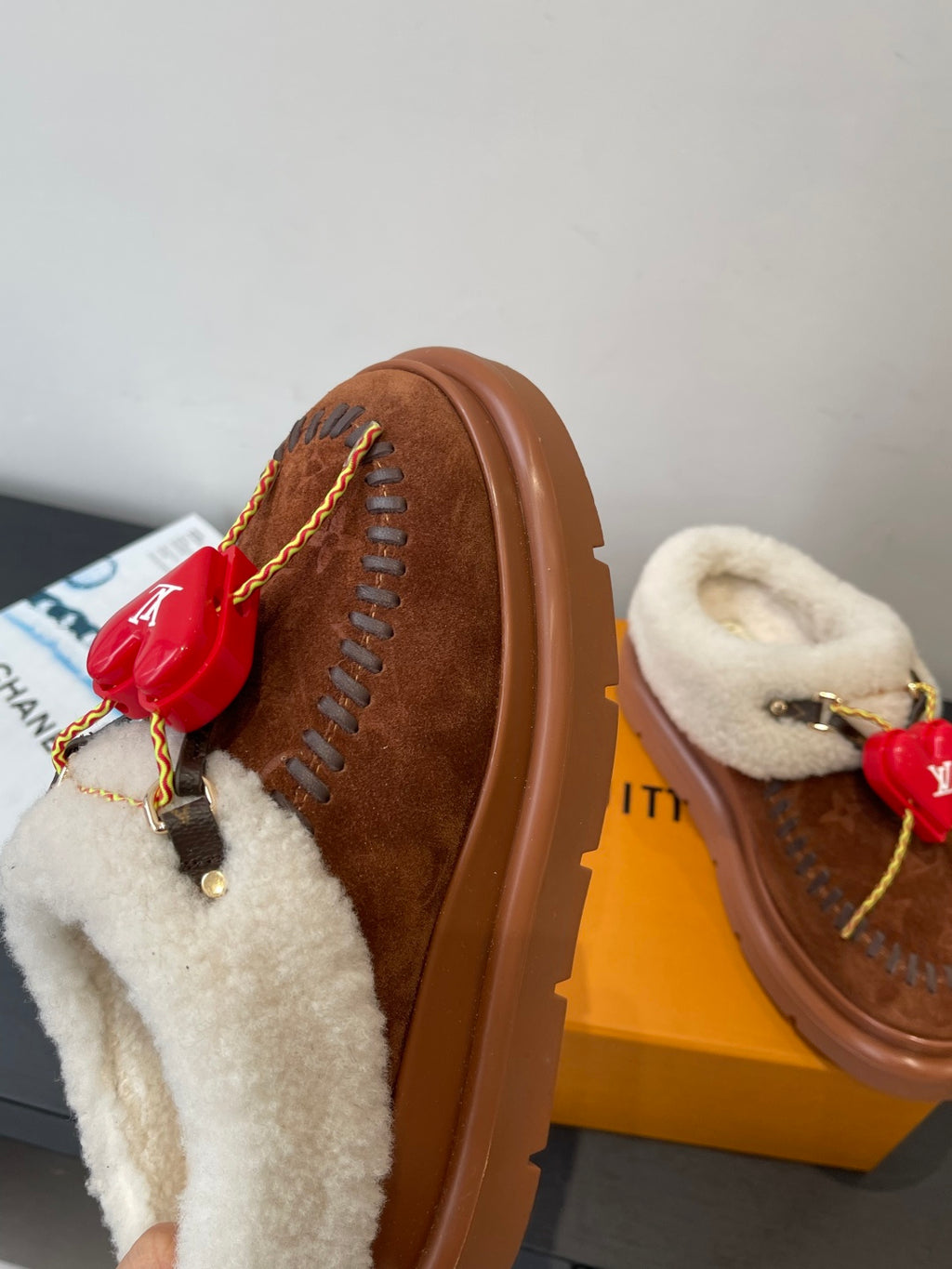 Brown suede slide with cream shearling lining red heart LV charm and lace-like stitching
