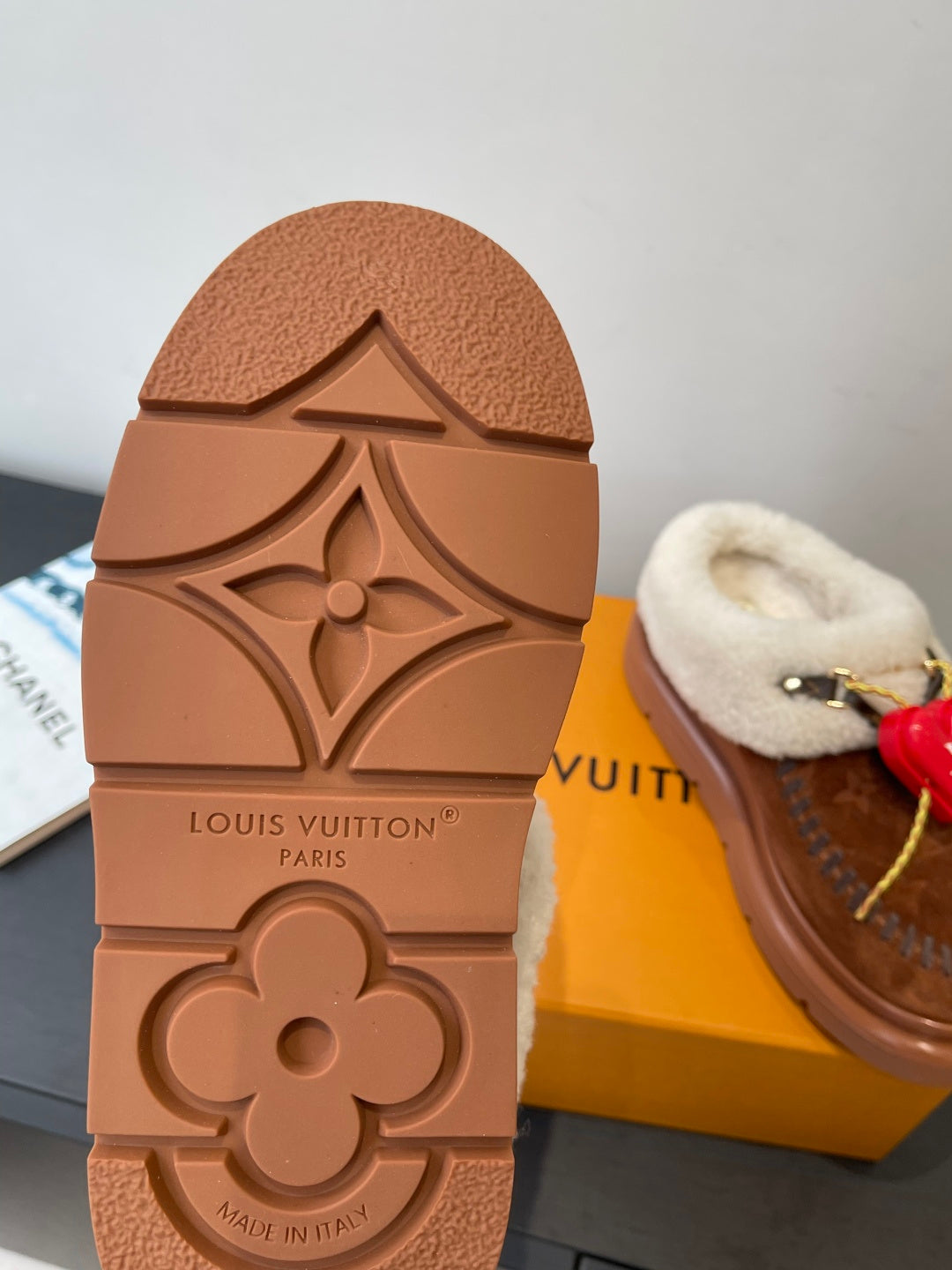 Embossed sole of brown Louis Vuitton slide with flower logo and “Made in Italy”