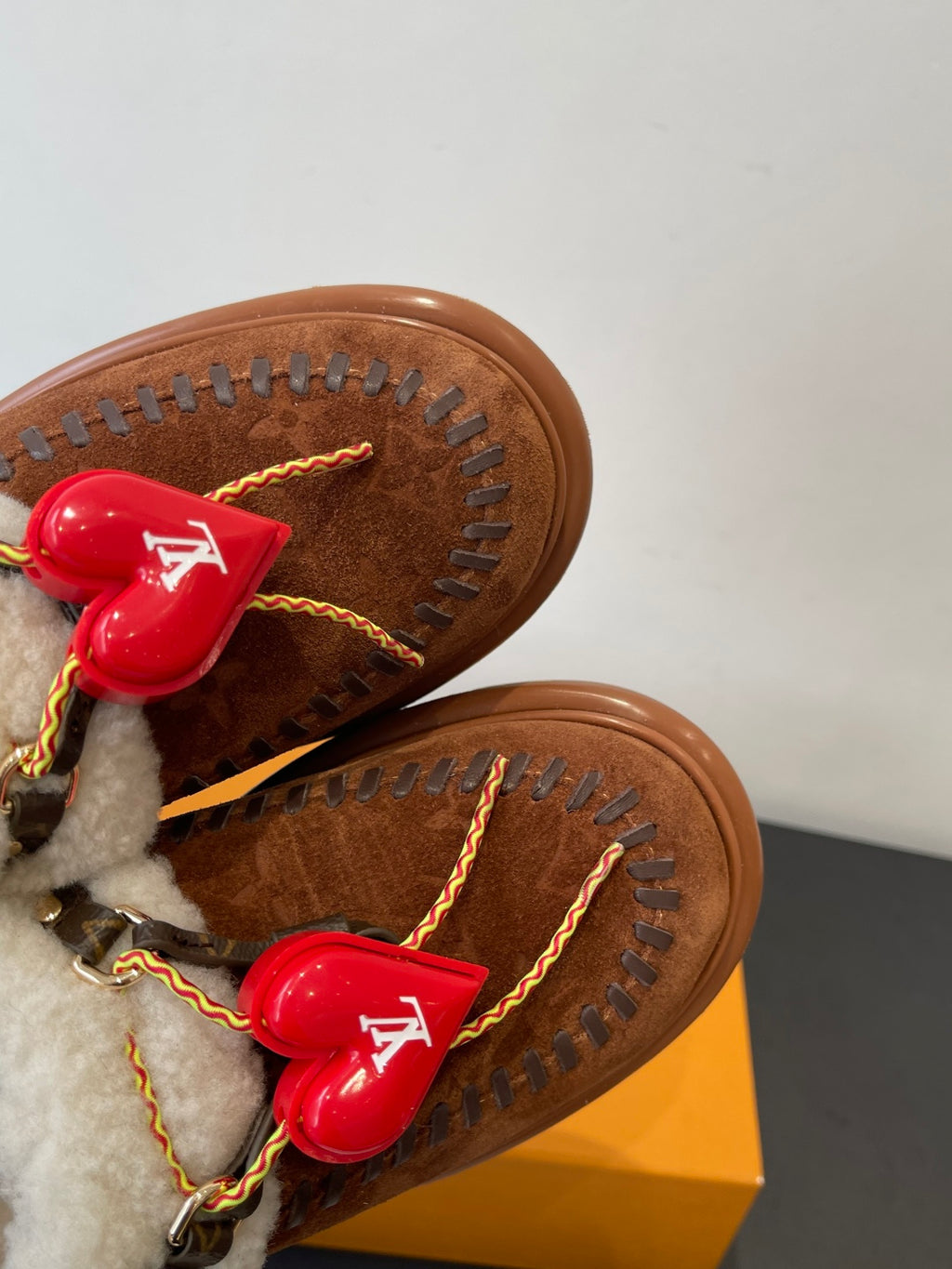 Close-up of brown suede upper and sole edge with red heart LV charm