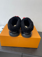 Black shearling slip-on shoes back view with red heart LV charm tabs