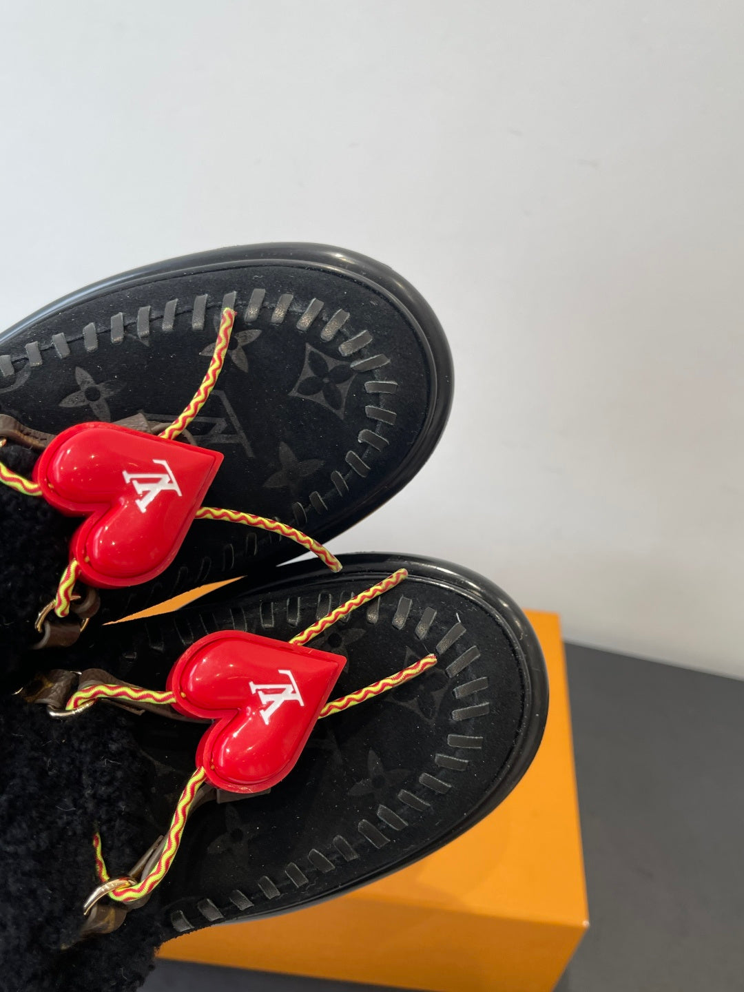 Black outsole tread detail with red heart LV charms and braided cord laces