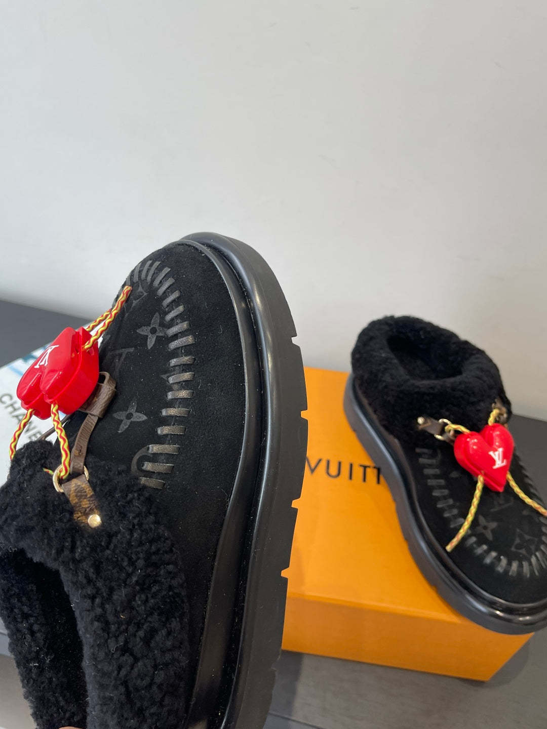 Black shearling slip-on shoe outsole edge with red heart LV charm