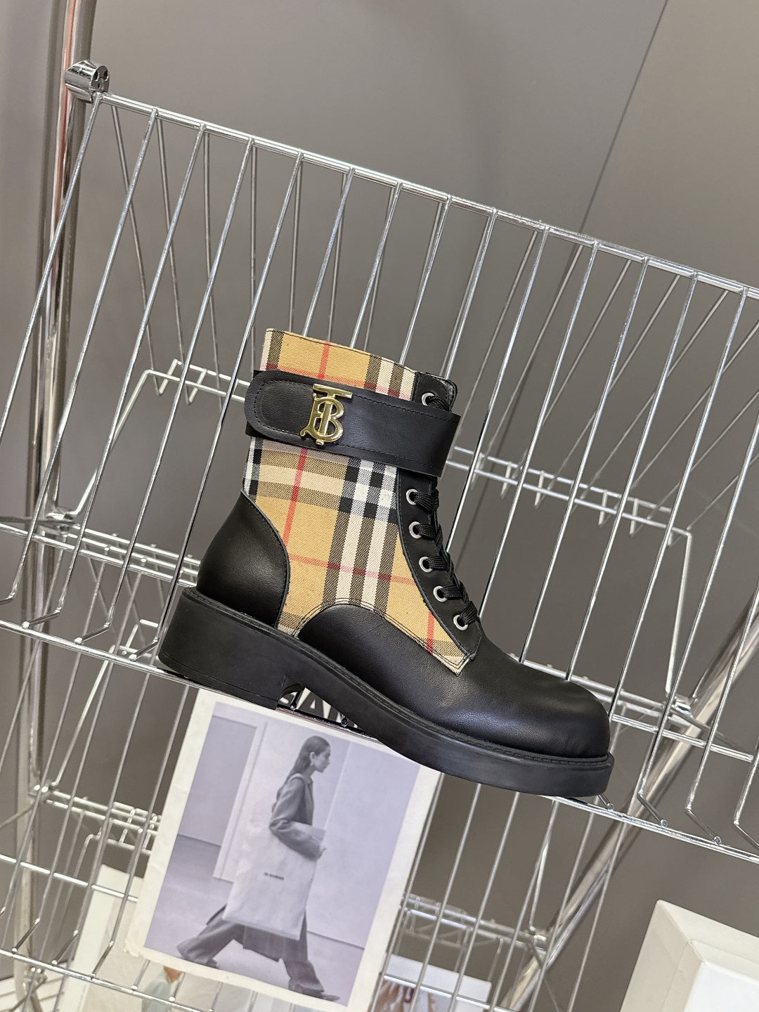 Black lace-up ankle boot with tan plaid side panel and gold-tone emblem