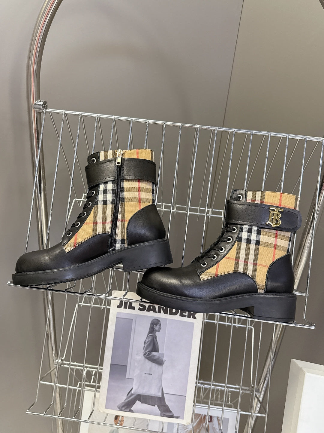 Two black lace-up ankle boots with tan, black, and red check side panels