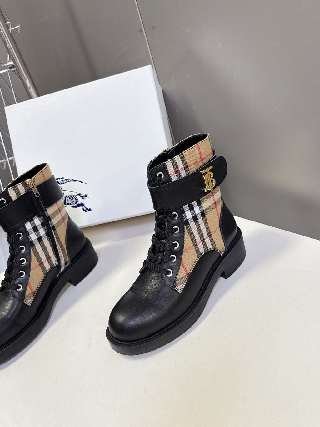 Pair of black lace-up ankle boots with plaid side panels and chunky sole