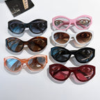 Assorted cat-eye sunglasses with tinted lenses in black, pink, brown, and red