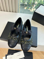 Black Chanel flats with bow and tweed upper panels on display