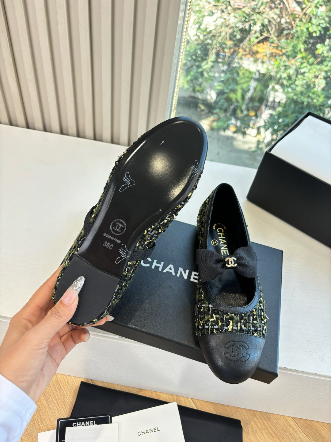 Black Chanel flats with tweed trim and bow detail, outsole side visible