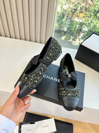 Black Chanel flats with bow and tweed side panel, shown from side angle