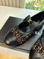 Black Chanel flat loafer close-up: multicolor tweed upper, CC logo, black bow