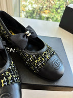 Close-up of black Chanel flats with bow and multicolor tweed toe panel