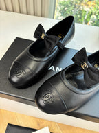 Black leather ballet flats with bow and Chanel CC logo on toe cap