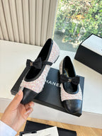 Black and tweed ballet flats with front bow detail, shown beside branded boxes