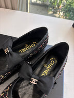 Black Chanel loafers detail: multicolor tweed upper with CC logo and satin bow