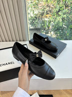 Black leather ballet flats with front bow and gold Chanel CC ornament