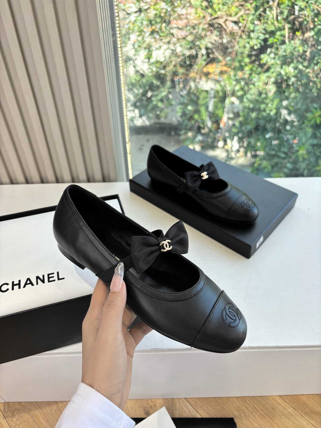 Black leather ballet flats with front bow and gold Chanel CC ornament