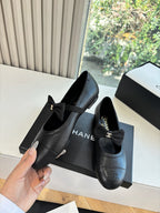 Black leather ballet flats with bow, Chanel CC emblem, and cushioned insole