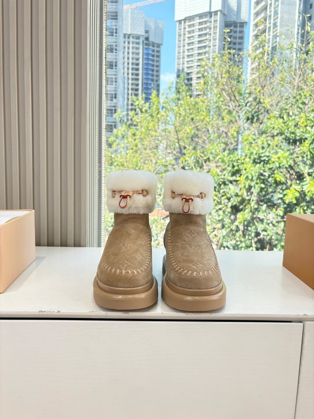 Tan unisex ankle boots with white shearling cuff and leather strap detail