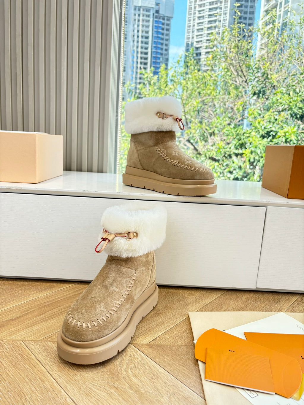 Tan ankle boots with white shearling top, side emblem, and tan platform sole